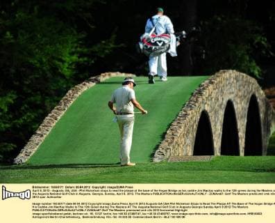 April 8, 2012 - Augusta, GA, USA - Phil Mickelson stops to read the plaque at the base of the Hogan Bridge as his caddie Jim Mackay walks to the 12th green during the Masters at the Augusta National Golf Club in Augusta, Georgia, Sunday, April 8, 2012. The Masters - ZUMAm67