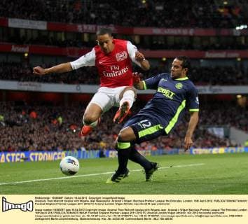 Arsenals Theo Walcott tussles with Wigans Jean Beausejour..Arsenal v Wigan, Barclays Premier League, the Emirates, London. 16th April 2012. EDITORIAL USE ONLY. No use with unauthorised audio, video, data, fixture lists, club league logos or live services. Online in-match use limited to 120 images, no video emulation. No use in betting, games or single club league player publications.