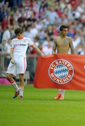 28.04.2012, Fussball 1.Bundesliga 2011 2012, 33.Spieltag, FC Bayern München, in der Allianz-Arena München. Die Bayernspieler bedanken sich nach dem Spiel bei den Anhängern mit diesem Transparent: Vielen Dank für Eure tolle Unterstützung in der Saison 2011-2012! v.li: Thomas Müller (Bayern München), Luiz Gustavo (München). Müller bereitet sich wohl schon auf die Dopingprobe vor.