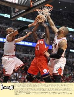 Philadelphia 76ers guard Jrue Holiday (C) goes up for a shot as Chicago Bulls forward Taj Gibson (L) and forward Carlos Boozer defend during the second quarter of game 5 of the first round of the Eastern Conference Playoffs at the United Center on May 1, 2012 in Chicago.  CHI2012050809