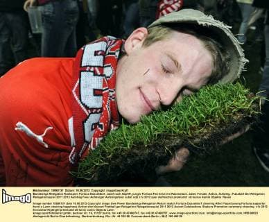 Bundesliga Relegation Rückspiel, Fortuna Düsseldorf, Jubel nach Abpfiff, junger Fortuna Fan herzt ein Rasenstück. Jubel, Freude, Aktion, Aufstieg.
