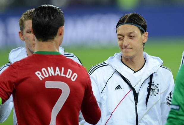 FUSSBALL EUROPAMEISTERSCHAFT 2012 VORRUNDE Deutschland - Portugal 09.06.2012 Mesut Özil (re, Deutschland) zwinkert Cristiano Ronaldo (li, Portugal) bei der Begrüßung zu 