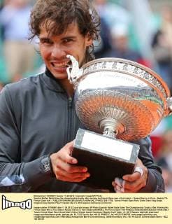 Spanish Rafael Nadal bites the championship trophy after winning his French Open men s final match - Roland Garros in Paris - Nadals 7th French Open title -  PAR20120611733