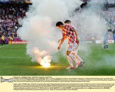 FUSSBALL EUROPAMEISTERSCHAFT 2012 VORRUNDE Italien - Kroatien 14.06.2012 Ivan Perisic (li) und Ognjen Vukojevic (re, beide Kroatien) kümmern sich um auf den Platzt geworfene Pyrotechnik 