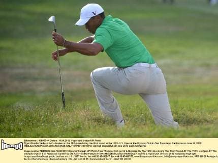 Tiger Woods climbs out of a bunker on the 16th hole during the third round at the 112th U.S. Open at the Olympic Club in San Francisco, California on June 16, 2012.  SFP20120616113