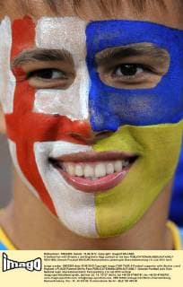 A football fan with Ukraine s and England s flags painted on his face  RE101854