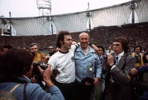 Die BR Deutschland ist Weltmeister 1974 - Kapitän Franz Beckenbauer (li.) jubelt mit Bundestrainer Helmut Schön inmitten der Fotografen