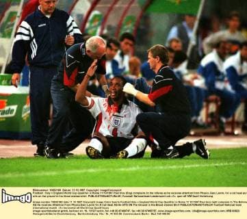 Football : Italy v England World Cup Qualifier in Rome.11 10 1997 Paul Ince (Eng) complains to the referee as he receives attention from Physio, Gary Lewin, for a cut head as he sits on the ground in his blood stained shirt. 