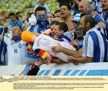 22.06.2012 - Gdansk , Poland . Griechische Fans mit einer Gummipuppe, die ein deutsches Trikot mit der Aufschrift Merkel, nach Bundeskanzlerin Angela Merkel, trägt  120622WAN005