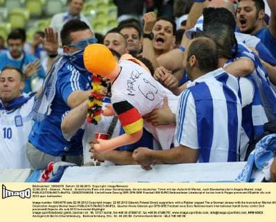 22.06.2012 - Gdansk , Poland . Griechische Fans mit einer Gummipuppe, die ein deutsches Trikot mit der Aufschrift Merkel, nach Bundeskanzlerin Angela Merkel, trägt  120622WAN004