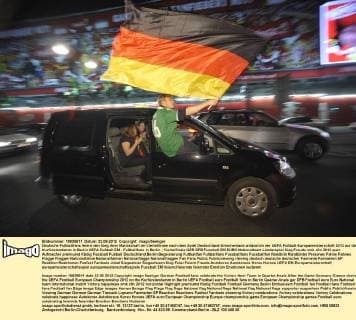 Deutsche Fußballfans feiern den Sieg ihrer Mannschaft im Viertelfinale nach dem Spiel Deutschland-Griechenland anlässlich der UEFA Fußball-Europameisterschaft 2012 auf dem Kurfürstendamm in Berlin UEFA Fußball EM - Fußballfans in Berlin