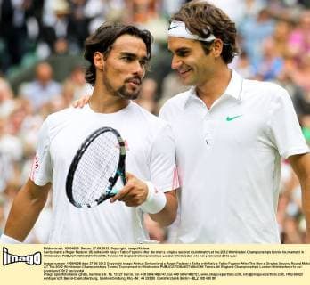 Switzerland s Roger Federer (R) talks with Italy s Fabio Fognini after the men s singles second round match at the 2012 Wimbledon Championships tennis tournament in Wimbledon 