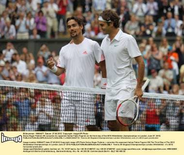 Swiss Roger Federer (R) consoles his opponent Italian Fabio Fognini on the third day of the 2012 Wimbledon championships in London, June 27, 2012.  LON2012062719