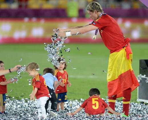 Fernando Torres (R) of Spain plays with children after the final match between Italy and Spain at the Euro 2012 football championships in Kiev, Ukraine, July 1, 2012. Spain won 4-0 to claim the title. - 