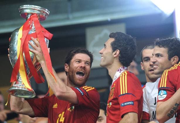 KIEV, JULY 1, 2012. Spain s Xabi Alonso (L) holds the Euro trophy (Cup) celebrating with his teammates victory against Italy in the final match of the UEFA European Football Championship (Euro 2012 final), at the Olympic Stadium in Kiev. Spain defeated Italy 4 - 0.  RE1026EB