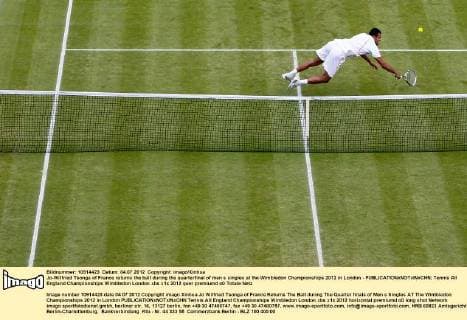 Jo-Wilfried Tsonga of France returns the ball during the quarterfinal of men s singles at the Wimbledon Championships 2012 in London - 