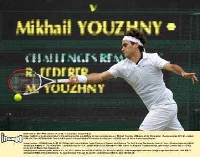 Roger Federer of Switzerland returns the ball during the quarterfinal of men s singles against Mikhail Youzhny of Russia at the Wimbledon Championships 2012 in London - 