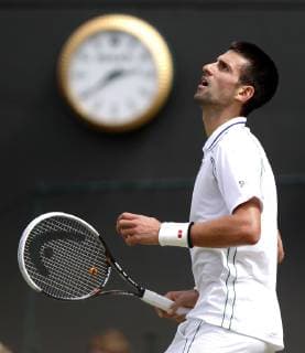Wimbledon Championships 2012 AELTC,London, ITF Grand Slam Tennis Tournament, Novak Djokovic (SRB) schaut nachoben;Uhr im Hintergrund, Einzelbild,Halbkoerper,Hochformat,