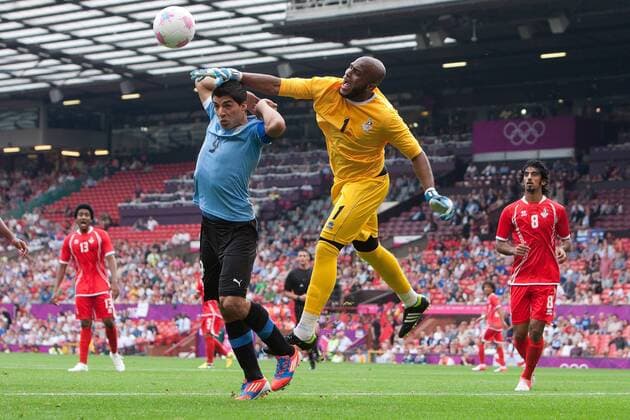 Football - London 2012 Olympics - United Arab Emirates vs. Uruguay Ali Khaseif of UAE clears the ball from Luis Suarez of Uruguay at Old Trafford, Manchester 