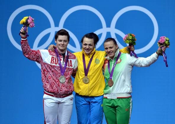 LONDON, Aug. 3, 2012 - Svetlana Podobedova of Kazakhstan (C), silver medalist Natalya Zabolotnaya of Russia (L), and bronze medalist Iryna Kulesha of Belarus celebrate at the awarding ceremony of women s 75kg weightlifting event at London 2012 Olympic Games, London, Britain, Aug. 3, 2012. 