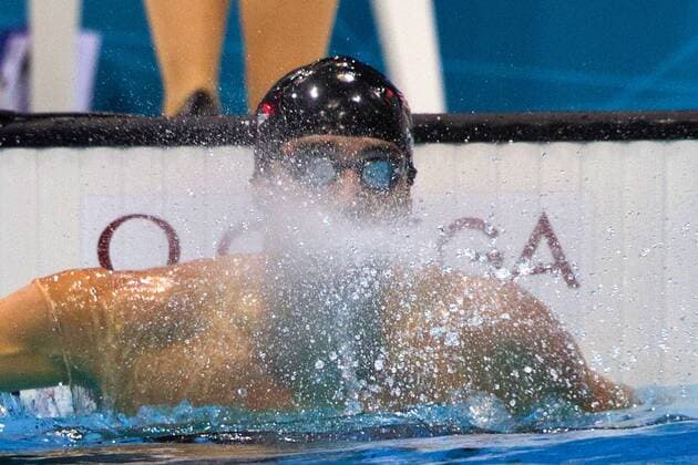 Michael PHELPS, USA, 1.Platz und Olympiasieger, im Ziel, prustet Wasser aus dem Mund; Prusten, herausblasen; Olympische Sommerspiele 2012 in London, Schwimmen, 100m Schmetterling der Maenner, Finale am 03.08.2012 in London Aquatics Centre Grossbritannien.