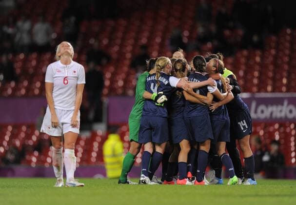 Canada s Kaylyn Kyle lifts her head skywards as the USA team celebrate the win.Canada v USA Olympic 2012 semi-final women s match at Old Trafford, Manchester United Kingdom on the 6th August 2012..Pic Simon Bellis SPORTIMAGE. EDITORIAL USE ONLY. No use with unauthorised audio, video, data, fixture lists, club league logos or live services. Online in-match use limited to 120 images, no video emulation. No use in betting, games or single club league player publications.
