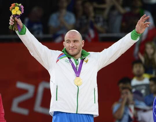 Artur Taymazov of Uzbekistan acknowledges the cheers of the crowd after receiving the Gold Medal for his victory over over Davit Modzmanashvili of Georgia in the Men s 120kg Freestyle Wrestling at the London 2012 Summer Olympics on August 10, 2012 in London.  OLY20120811305