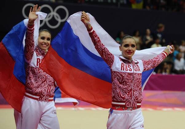 LONDON, UK. AUGUST 12, 2012. Gold medallists Russia s gymnasts hold national flags during the medal ceremony for the women s rhythmic gymnastics group all-around at the London 2012 Olympic Games.  RE105C29