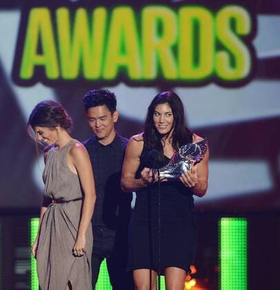 The U.S. women s soccer team goalie Hope Solo accepts her trophy from actors Nikki Reed (L) and John Cho after being selected the Athlete winner, beating out Cristiano Ronaldo, LeBron James, Tim Tebow and Serena Williams, during the Do Something Awards at Barker Hangar in Santa Monica, California on August 19, 2012.  LAP2012081930