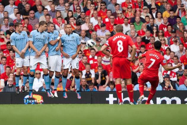 Football - Premier League - Liverpool vs. Manchester City Luis Suarez of Liverpool curls a free kick around the Manchester City wall to score his sides second goal at Anfield 