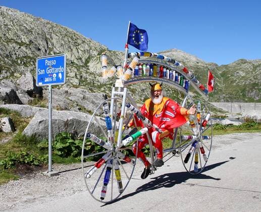 27.08.2012 Radsport. Bild zeigt Tourteufel Didi Senft bei seinem zwischenhalt auf dem Gotthardpass (Bild) mit seinem Spezialrad (Trinkflaschen diverser Radrennfahrer) auf dem Weg zur Eurobike nach Friedrichshafen GER Aktion Radsport Tourteufel 