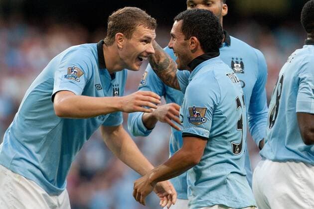 Football - Premier League - Manchester City vs. Queens Park Rangers QPR Edin Dzeko of Manchester City congratulates Carlos Tevez on his goal at the Etihad Stadium 