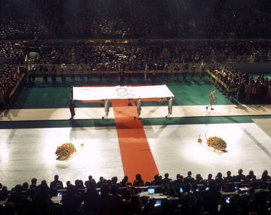 Abschlussfeier der olympischen Winterspiele 1976 in Innsbruck - Die olympische Fahne wird präsentiert