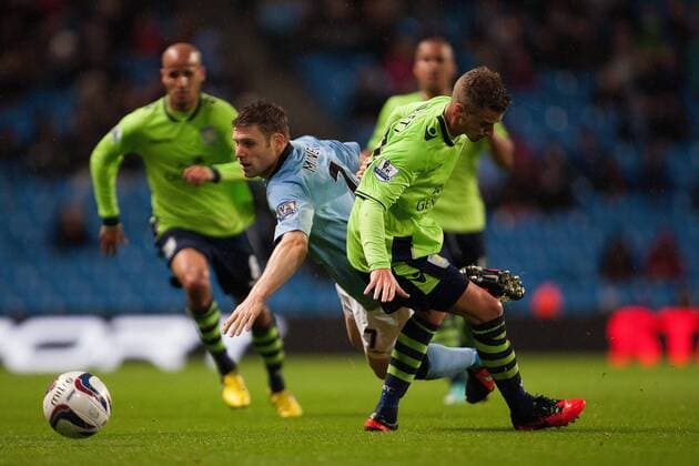 Capital One Cup - Manchester City vs. Aston Villa -- Joe Bennett of Villa challenges James Milner of Manchester City at the Etihad Stadium 