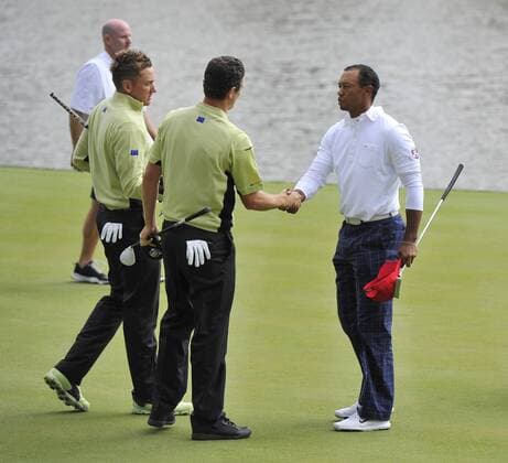Team Europe s Justin Rose of England (C) shakes hands with Team USA s Tiger Woods (R) after Rose and teammate Ian Poulter of England defeated Woods and Steve Stricker in their match at the 39th Ryder Cup at Medinah Country Club on September 28, 2012 in Medinah, Illinois.  BKX2012092860