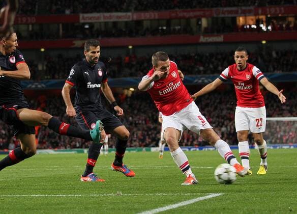 Arsenal s Lukas Podolski scoring his sides second goal..Football - Champions League Matchday 2 - Emirates Stadium, London - 3 10 12EDITORIAL USE ONLY. EDITORIAL USE ONLY. No use with unauthorised audio, video, data, fixture lists, club league logos or live services. Online in-match use limited to 120 images, no video emulation. No use in betting, games or single club league player publications.