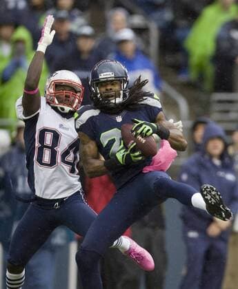 Seattle Seahawks cornerback Richard Sherman intercepts a pass intended for New England Patriots wide receiver Deion Branch at CenturyLink Field in Seattle, Washington on October 14, 2012. With 1:18 remaining the Seahawks rallied for 14 points to stun the New England Patriots 24-23.  SEA2012101413