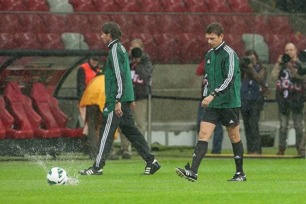Football - World Cup Qualifier - Poland vs. England Italian referee Gianluca Rocchi watches the ball make a splash as he inspects the pitch at the National Stadium, Warsaw 