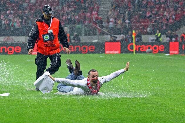 16.10.2012 WARSAW 2014 FIFA WORLD CUP BRAZIL QUALIFIERS POLAND VS ENGLAND Fan flitzt beim Regen über das Spielfeld  20121016CSJP3013