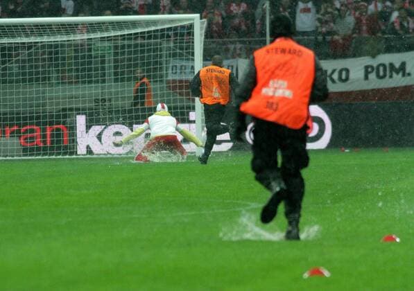 16.10.2012, Warsaw, Poland. World Cup qualification match. Poland versus England. The match pitch before the game is waterlogged and a pitch invader eludes security staff in the rain xADAMxJASTRZEBOWSKIx  ActionPlus20197580