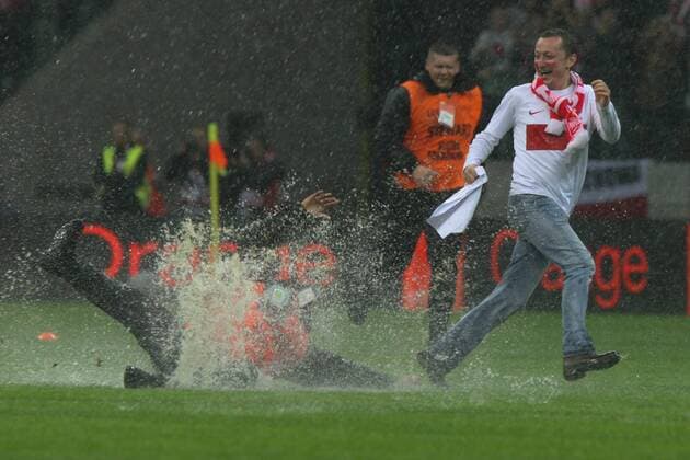 16.10.2012, Warsaw, Poland. World Cup qualification match. Poland versus England. The match pitch before the game is waterlogged and a pitch invader eludes security staff in the rain xADAMxJASTRZEBOWSKIx  ActionPlus20197581