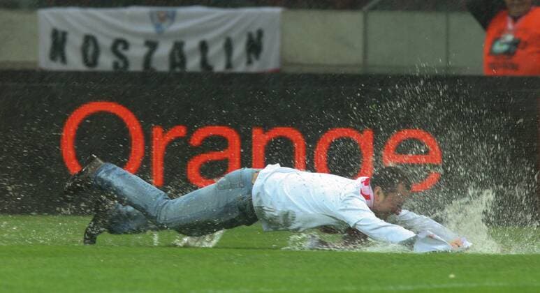 16.10.2012, Warsaw, Poland. World Cup qualification match. Poland versus England. The match pitch before the game is waterlogged and a pitch invader eludes security staff in the rain xADAMxJASTRZEBOWSKIx  ActionPlus20197582