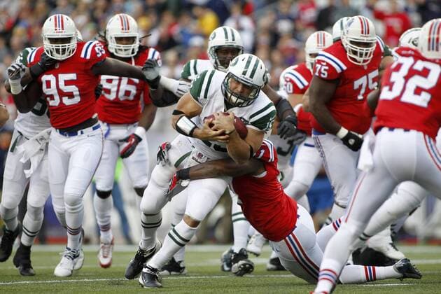 New York Jets quarterback Tim Tebow (15) charges into the arms of New England Patriots linebacker Jerod Mayo (51) on a three yard cary in the first quarter at Gillette Stadium in Foxboro, Massachusetts on October 21, 2012.  BOS2012102106
