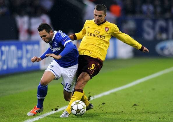 Fussball, UEFA Champions League, Herren, Saison 2012 2013, 4. Spieltag, Gruppe B, Veltins-Arena Gelsenkirchen, FC Schalke 04 (blau) - Arsenal London (gelb) 2:2; Marco Höger, Hoeger (S04), Lukas Podolski (Arsenal), Aktion.