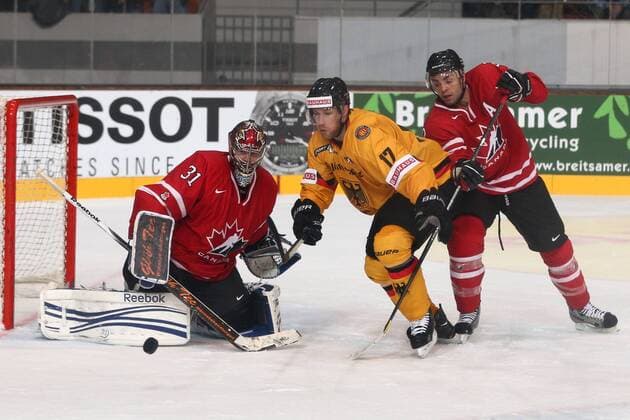 Eishockey Deutschland-Cup: Deutschland - Kanada am Freitag (09.11.2012) in der Olympia-Eissporthalle in München Sebastien Caron ( Kanada ), links - Marcus Kink ( Deutschland ), mitte - Chris Lee ( Kanada ), rechts