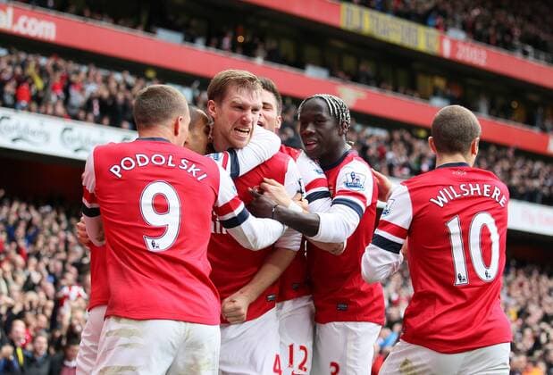 Arsenal s Per Mertesacker celebrates with goalscorer Lukas Podolski ..Arsenal FC London v Tottenham Hotspur - Premier League- Emirates Stadium, London- 17 11 12 - EDITORIAL USE ONLY. No use with unauthorised audio, video, data, fixture lists, club league logos or live services. Online in-match use limited to 120 images, no video emulation. No use in betting, games or single club league player publications.