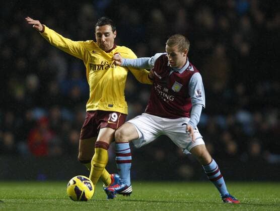 Football -Premiership - Aston Villa vs FC Arsenal London- Arsenal s Santi Cazorla and Aston Villa s Barry Bannon battle for the ball at Villa Park. 