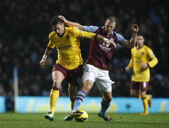 Football -Premiership - Aston Villa vs FC Arsenal London- Arsenal s Olivier Giroud and Aston Villa s Ron Vlaar battle for the ball at Villa Park. 