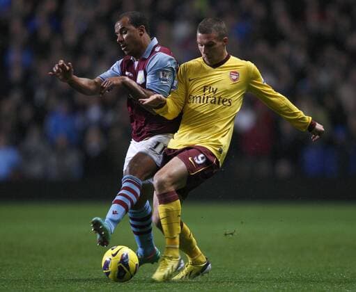 Football -Premiership - Aston Villa vs FC Arsenal London- Arsenal s Lukas Podolski and Aston Villa s Gabriel Agbonlahor battle for the ball at Villa Park. 
