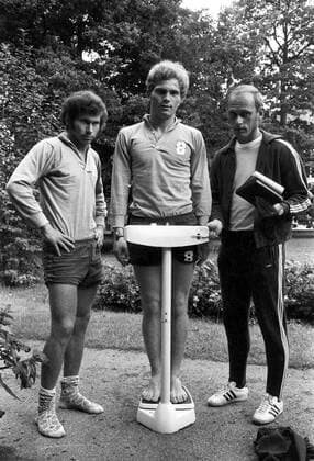 Uli Hoeneß (Mitte) auf der Waage, daneben Paul Breitner (li.) und Trainer Udo Lattek (alle FC Bayern München)